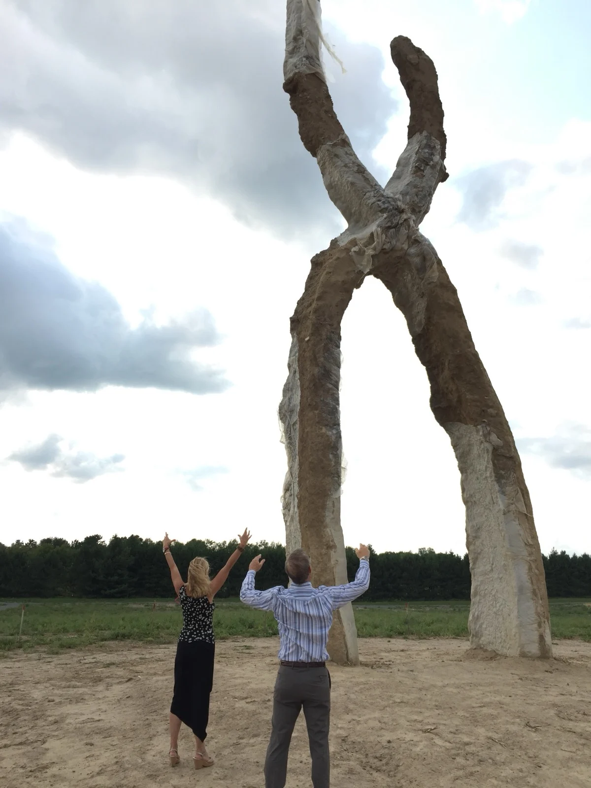 Two figures rising on their own and meeting as one. That is interdependence. | A sculpture of two forms joining into a single arch with Zac Spowart's parents standing beneath, a metaphor for interdependence versus independence in love by Zac Spowart, Love Unlocked. Two figures rising on their own and meeting as one. That is interdependence. | A sculpture of two forms joining into a single arch with Zac Spowart's parents standing beneath, a metaphor for interdependence versus independence in love by Zac Spowart, Love Unlocked.
